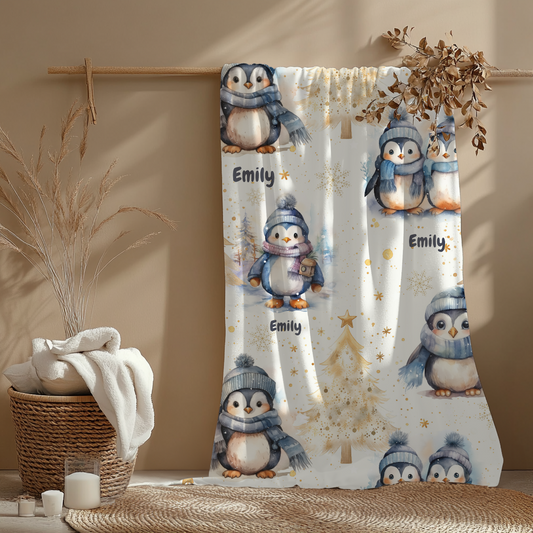 Babydecke mit Pinguin – personalisierbar hängt über einer Holzstange